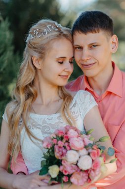 Gelin ve damat gün açık havada yürüyüş düğününde doğa bahar. Gelin Çift, mutlu yeni evli kadın ve yeşil park kucaklayan adam. Sevgi dolu evlilik çift açık. Gelin ve damat, düğün çekim