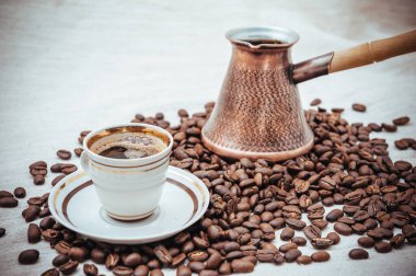 Çuval bezi üzerine kahve ve Türk kahvesi. Beyaz arka planda izole kahve çekirdekleri. Kavrulmuş kahve çekirdeği.