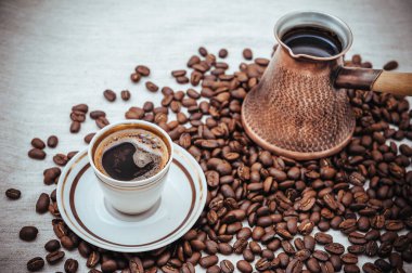 Çuval bezi üzerine kahve ve Türk kahvesi. Beyaz arka planda izole kahve çekirdekleri. Kavrulmuş kahve çekirdeği.