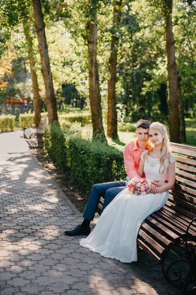 Novia y novio en el día de la boda caminando al aire libre en la naturaleza de primavera. Pareja nupcial, feliz mujer recién casada y hombre abrazándose en el parque verde. Amar pareja de boda al aire libre. Boda de novia y novio en —  Fotos de Stock