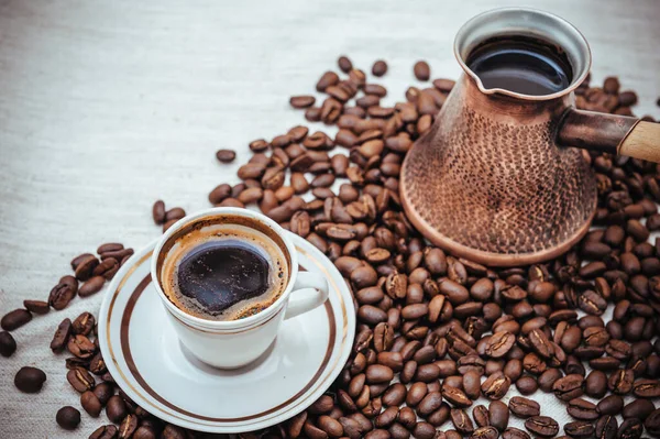 Kaffee-Türke und Tasse Kaffee auf Klett-Hintergrund. Kaffeebohnen isoliert auf weißem Hintergrund. geröstete Kaffeebohnen — Stockfoto