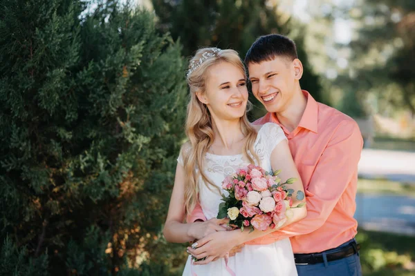 Menyasszony és a vőlegény az esküvő nap séta kint a tavaszi természet. Nászutas pár, boldog Newlywed nő és férfi átfogó zöld parkban. Szerető szabadtéri esküvő házaspár. A menyasszony és a vőlegény az esküvő shot — Stock Fotó