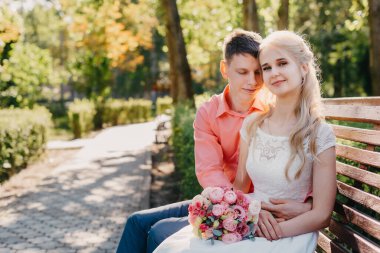 Gelin ve damat gün açık havada yürüyüş düğününde doğa bahar. Gelin Çift, mutlu yeni evli kadın ve yeşil park kucaklayan adam. Sevgi dolu evlilik çift açık. Gelin ve damat, düğün çekim