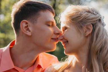 Gelin ve damat gün açık havada yürüyüş düğününde doğa bahar. Gelin Çift, mutlu yeni evli kadın ve yeşil park kucaklayan adam. Sevgi dolu evlilik çift açık. Gelin ve damat, düğün çekim