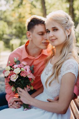 Gelin ve damat gün açık havada yürüyüş düğününde doğa bahar. Gelin Çift, mutlu yeni evli kadın ve yeşil park kucaklayan adam. Sevgi dolu evlilik çift açık. Gelin ve damat, düğün çekim