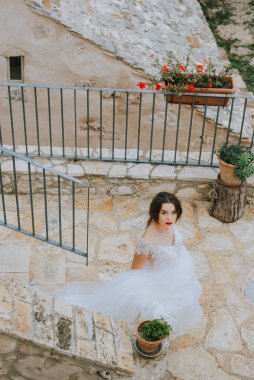 Eski şatoda yürüyen gelinlik lüks elbiseler içinde şık bir gelin. Şatoda yürüyen günbatımında lüks gelinlik içinde şık bir gelin. Güzel, zarif.