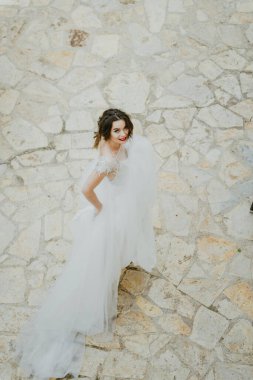 Eski şatoda yürüyen gelinlik lüks elbiseler içinde şık bir gelin. Şatoda yürüyen günbatımında lüks gelinlik içinde şık bir gelin. Güzel, zarif.