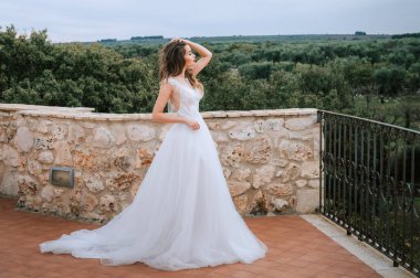 Eski şatoda yürüyen gelinlik lüks elbiseler içinde şık bir gelin. Şatoda yürüyen günbatımında lüks gelinlik içinde şık bir gelin. Güzel, zarif.