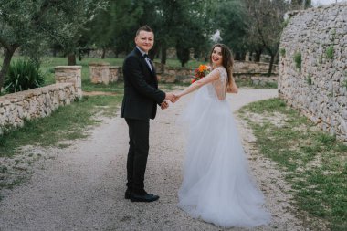 Tuscany, İtalya 'da düğün günlerinde yürüyen mutlu, güler yüzlü bir çift. Gelin ve damat sokakta ellerinin arasında yürürler. Genç ve şık bir çift yürüyor. Karı koca güzelce anlaşıyorlar.