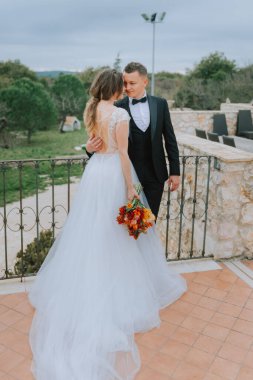 Tuscany, İtalya 'da düğün günlerinde yürüyen mutlu, güler yüzlü bir çift. Gelin ve damat sokakta ellerinin arasında yürürler. Genç ve şık bir çift yürüyor. Karı koca güzelce anlaşıyorlar.