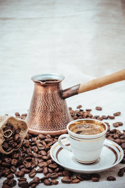 Kaffee-Türke und Tasse Kaffee auf Klett-Hintergrund. Kaffeebohnen isoliert auf weißem Hintergrund. geröstete Kaffeebohnen — Stockfoto