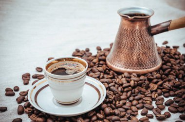 Çuval bezi üzerine kahve ve Türk kahvesi. Beyaz arka planda izole kahve çekirdekleri. Kavrulmuş kahve çekirdeği.