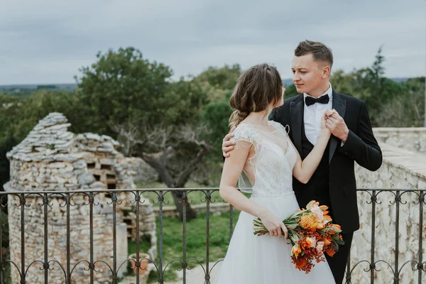 Tuscany, İtalya 'da düğün günlerinde yürüyen mutlu, güler yüzlü bir çift. Gelin ve damat sokakta ellerinin arasında yürürler. Genç ve şık bir çift yürüyor. Karı koca güzelce anlaşıyorlar.
