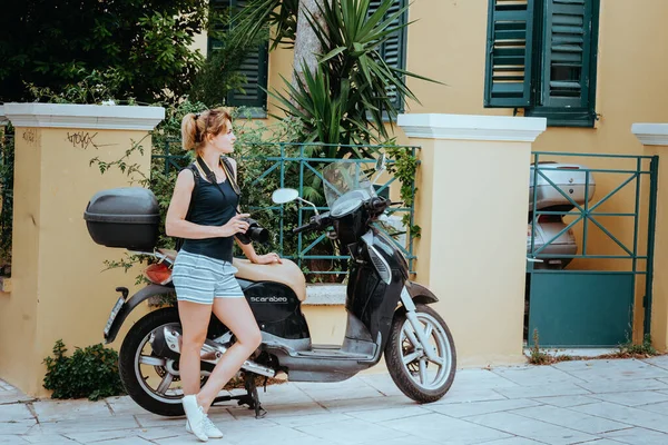 Bella ragazza che cammina lungo la strada di una vecchia città europea con una macchina fotografica in mano. Ritratto di una ragazza turistica che cammina sullo sfondo della strada. — Foto Stock