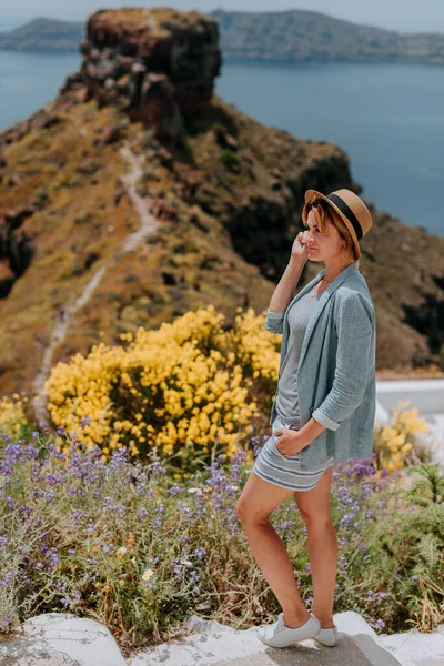 산토리니는 휴가중에오이아를걷고 있는 관광객 여자를 방문한다. 지중해와 푸른 돔 이 있는 유명 한 백인 마을을 방문하는 소녀. 유럽의 여름 휴양지. 뒤에 있는 아름다운 소녀 — 스톡 사진