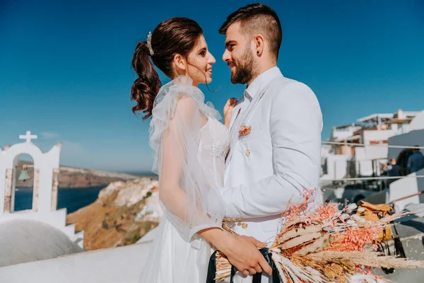 Beautiful bride and groom in their summer wedding day on greek island Santorini — Stock Photo, Image