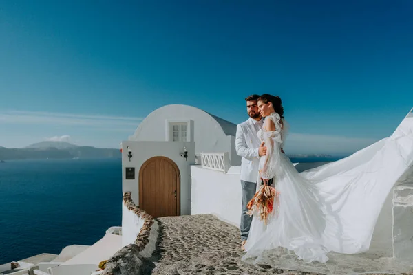 Beautiful bride and groom in their summer wedding day on greek island Santorini — Stock Photo, Image