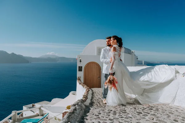 Hermosa novia y novio en el día de su boda de verano en la isla griega Santorini — Foto de Stock