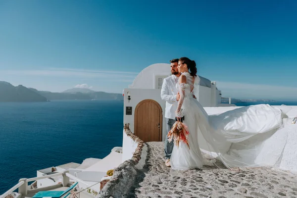 Beautiful bride and groom in their summer wedding day on greek island Santorini — Stock Photo, Image