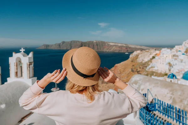 Santorini turismo mujer de vacaciones en Oia caminar. Chica visitando el famoso pueblo blanco con el mar Mediterráneo y cúpulas azules. Europa destino de verano. Hermosa chica en el fondo — Foto de Stock
