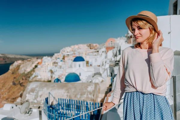 Santorini turismo mujer de vacaciones en Oia caminar. Chica visitando el famoso pueblo blanco con el mar Mediterráneo y cúpulas azules. Europa destino de verano. Hermosa chica en el fondo — Foto de Stock