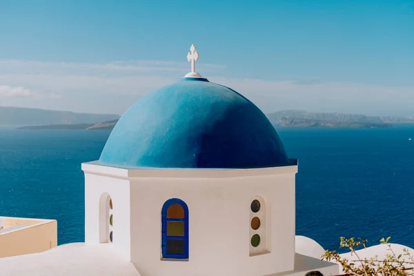 La chiesa a cupola blu di Oia si affaccia sulla spettacolare caldera che circonda la bellissima isola di Santorini, Grecia — Foto Stock