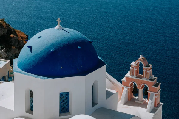 La chiesa a cupola blu di Oia si affaccia sulla spettacolare caldera che circonda la bellissima isola di Santorini, Grecia — Foto Stock