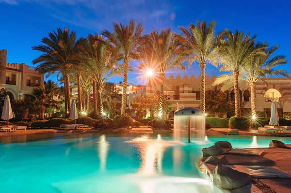 Vista noturna da bela piscina e palmeiras no Egito — Fotografia de Stock