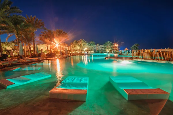 Vista noturna da bela piscina e palmeiras no Egito — Fotografia de Stock