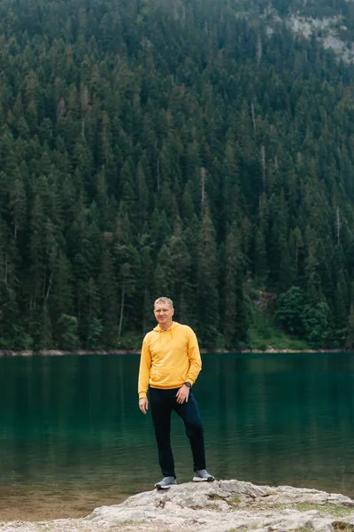 Hombre viajero meditación relajante con serenas montañas vista y paisaje del lago. Viajes Estilo de vida senderismo concepto vacaciones de verano al aire libre. Un tipo parado cerca del lago de la montaña. Un hombre solitario mira hacia adelante —  Fotos de Stock