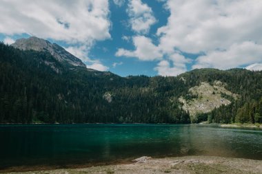 Karadağ 'ın Durmitor Ulusal Parkı' ndaki Dağ Gölü. Dağın temiz su ve parlak mavi gökyüzü ile güzel bir zemin manzarası var.