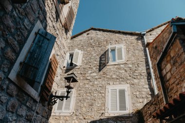 Town, Budva, Karadağ. Balkanlar 'da dükkanları, kafeleri ve restoranları olan iyi korunmuş eski ortaçağ kasabasındaki resim meydanı. Budva 'nın ortaçağ kalesi St. Mary Kalesi manzarası.
