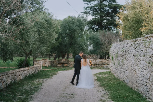 在意大利托斯卡纳，一对笑容满面的情侣在他们的婚礼日快乐地散步。新娘和新郎手拉手沿街走着.一对年轻貌美的夫妇散步.夫妻之间的沟通很好 — 图库照片