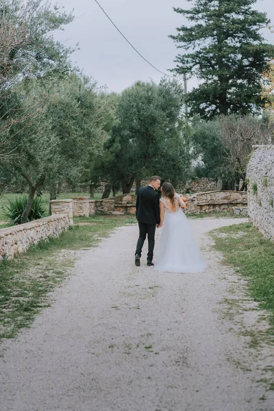 在意大利托斯卡纳，一对笑容满面的情侣在他们的婚礼日快乐地散步。新娘和新郎手拉手沿街走着.一对年轻貌美的夫妇散步.夫妻之间的沟通很好 — 图库照片
