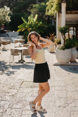 MEDITERRANEAN MEDİEVAL ŞEHRİ, OLD TOWN BUDVA, MONTENEGRO 'DA Güzel bir Yaz Günü' nde Antik Narrow Caddesi 'nde Yürüyen Kız Turist. Genç, güzel, neşeli bir kadın Old Street 'te yürüyor.