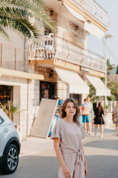 Девушка турист ходить по древней узкой улице в красивый летний день в МЕДИТЕРРАНЕЙСКИЙ МЕДИЕВАЛЬНЫЙ ГОРОД, Монтенегро. Молодая красивая веселая женщина гуляет по старой улице в тропическом городе. Претти — стоковое фото