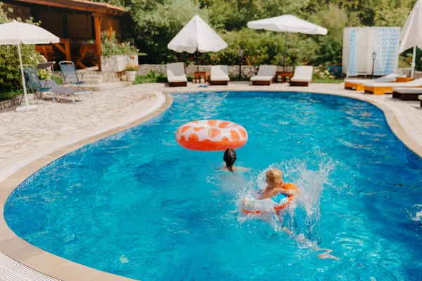 Niño feliz divirtiéndose en vacaciones de verano. Niño jugando con pato de goma y pelota en el mar. Concepto de estilo de vida saludable. Feliz niño jugando en la piscina. Concepto vacaciones de verano — Foto de Stock