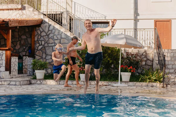 Google 'da heyecanlı bir çocuk babasının yüzme havuzunda duran omuzlarından suya atlıyor.