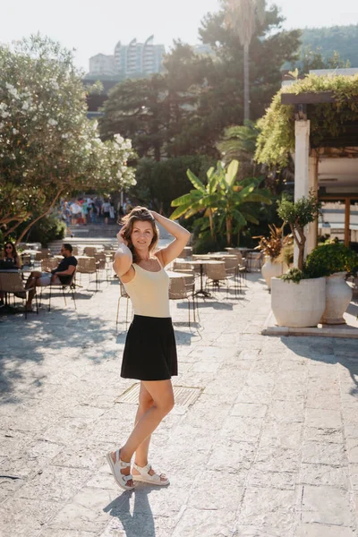 MEDITERRANEAN MEDİEVAL ŞEHRİ, OLD TOWN BUDVA, MONTENEGRO 'DA Güzel bir Yaz Günü' nde Antik Narrow Caddesi 'nde Yürüyen Kız Turist. Genç, güzel, neşeli bir kadın Old Street 'te yürüyor.