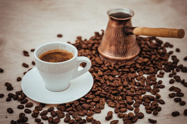 Çuval bezi üzerine kahve ve Türk kahvesi. Beyaz arka planda izole kahve çekirdekleri. Kavrulmuş kahve çekirdeği.