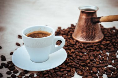 Çuval bezi üzerine kahve ve Türk kahvesi. Beyaz arka planda izole kahve çekirdekleri. Kavrulmuş kahve çekirdeği.