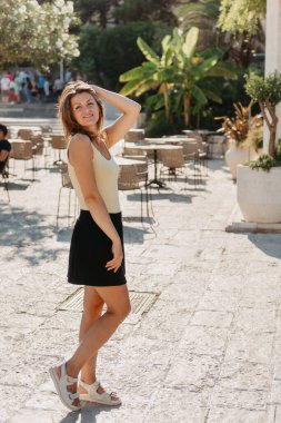 MEDITERRANEAN MEDİEVAL ŞEHRİ, OLD TOWN BUDVA, MONTENEGRO 'DA Güzel bir Yaz Günü' nde Antik Narrow Caddesi 'nde Yürüyen Kız Turist. Genç, güzel, neşeli bir kadın Old Street 'te yürüyor.