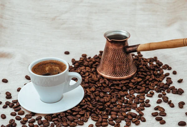 Çuval bezi üzerine kahve ve Türk kahvesi. Beyaz arka planda izole kahve çekirdekleri. Kavrulmuş kahve çekirdeği.