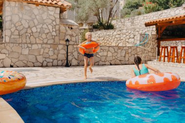Mutlu çocuk yaz tatilinde eğleniyor. Çocuk denizde lastik ördek ve topla oynuyor. Sağlıklı yaşam tarzı kavramı. Mutlu çocuk yüzme havuzunda oynuyor. Yaz tatilleri konsepti