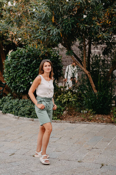 Девушка Туристический отдых на древней узкой улице в прекрасный летний день в МЕДИТЕРРАНЕЙСКИЙ МЕДИЕВАЛЬНЫЙ ГОРОД, старый город Котор, Монтенегро. Молодая красивая веселая женщина ходит по Старой улице