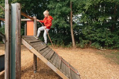 Çocuk parkında oynayan komik, sevimli, mutlu bebek. Mutluluk duygusu, eğlence, neşe. Bir çocuğun gülümsemesi. Çocuk parkta oynuyor..