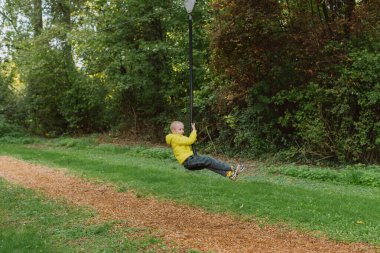 Çocuk Bungee jumping yaz ormanda.