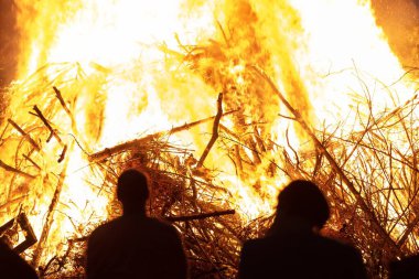 people silhouettes in front of burning fire