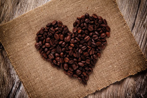 Heart made from coffee beans on a burlap — Stock Photo, Image