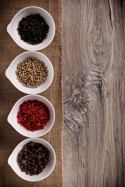 Fresh black, white, pink pepper into a porcelain bowls — Stock Photo, Image